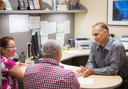 A NOCE counselor talking to a student and the student's wife for his counselor appointment.